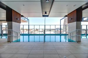 阿德莱德Stunning 2BR Apt @ Adelaide CBD with Pool-Gym-BBQ的一座建筑物中央的游泳池