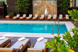 马德里Wellington Hotel & Spa Madrid的一个带躺椅的游泳池和一个游泳池