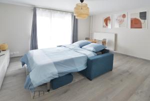 Évry-les-ChâteauxLa Villa des Arts的一间卧室配有蓝色的床和蓝色枕头