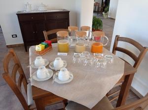 CapestranoAgriRelais San Giovanni的桌子,上面有杯子和橙汁杯