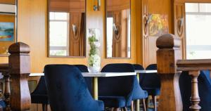圣皮埃尔－迪沃夫赖Hostellerie Saint Pierre的一间带桌子和蓝色椅子的用餐室