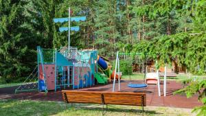皮什Wiartel Osrodek Wypoczynkowy的公园内的一个游乐场,有长凳