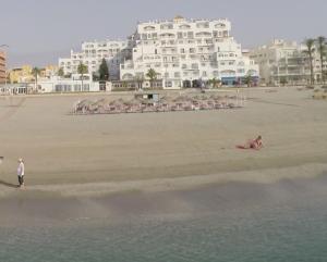 滨海罗克塔斯巴伊亚塞琳娜酒店的海滩上的人,背景是酒店
