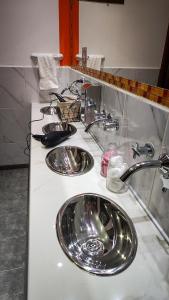 乌斯怀亚南极物语旅馆的浴室内带3个盥洗盆的浴室台