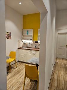 佛罗伦萨Resort del Roster的厨房设有黄色的墙壁和桌椅