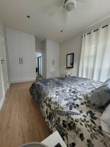 伊丽莎白港Downstairs @38的一间卧室配有一张大床和鲜花毯子