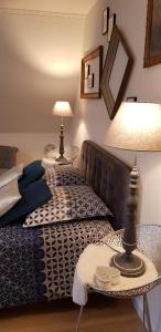 NiederbronnMaison d'Hôtes "L'ORIGINALE"的一间卧室配有沙发和两张台灯桌