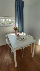 阿尔加罗沃Cabaña con fogon y tinaja en plena naturaleza!的窗户客房内的白色桌椅