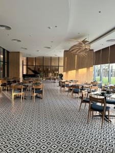 Miếu ÔngThe Arena Cam Ranh Resort all Luxury Service的一间带桌椅和钢琴的餐厅
