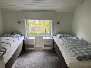 莫尔德Sjarmerende gårdsbruk omgitt av vakker natur的带窗户的客房内的两张床