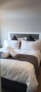 比勒陀利亚Menlyn Maine Trilogy Apartment 808的一张配有白色床单和枕头的大床