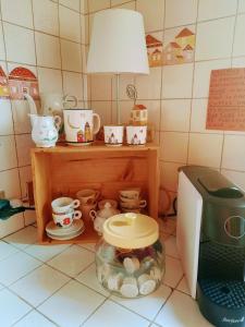 伊莫拉Cà Rossa的厨房配有微波炉和桌子,桌子上放有杯子和餐具