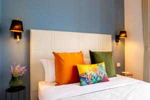 卡利亚里Magnini Rooms的一间卧室配有带色彩缤纷枕头的床