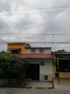 拉多拉达Casa de relajación low cost的黄色和白色的建筑,有红色屋顶