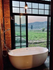 Ban Yang Huai TongThe Maewin Coffee & Cottage Economy Twin Room的窗户客房内的大浴缸