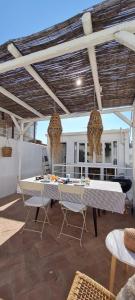 奥良Lavadeira's House的一个带桌椅的庭院和一个屋顶