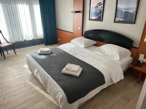 布鲁塞尔Hotel EUROPACITY的一间卧室配有一张大床和两条毛巾