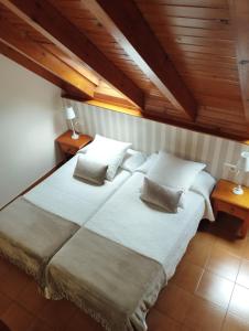 维耶拉Hotel Ostau d'Òc的卧室配有一张带白色床单和枕头的大床。