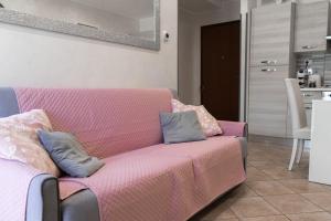 奥斯蒂亚·安提卡Casetta 46的客厅配有粉红色的沙发及枕头