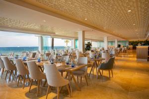 普拉亚登博萨Hotel Torre del Mar - Ibiza的一间设有桌椅的海洋餐厅