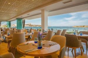 普拉亚登博萨Hotel Torre del Mar - Ibiza的一间带桌椅的海景餐厅