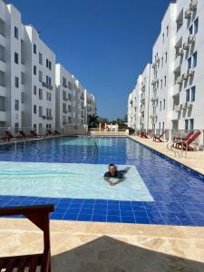 科韦尼亚斯Hermoso Apartamento en Caribe Campestre的一个人在酒店的游泳池游泳