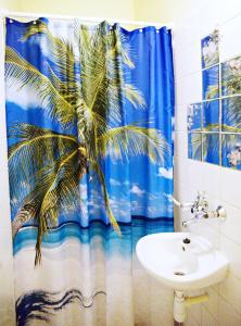 尼赖吉哈佐Jocó Panzió的浴室设有棕榈树淋浴帘和水槽
