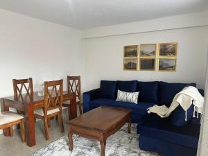 KerichoZoe Homes Oak Villa Apartment 1 and 2 Bedroom 201的客厅配有蓝色的沙发和桌子