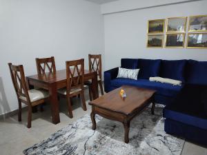 KerichoZoe Homes Oak Villa Apartment 1 and 2 Bedroom 201的客厅配有蓝色的沙发和桌子