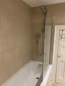 伦敦Beautiful double room in a central location next to various tube stations with breakfast and yoga options available on site的带淋浴和浴缸的浴室