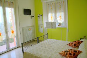 VillagrandeB&B Il Poggio的一间卧室设有一张带绿色墙壁和窗户的床。