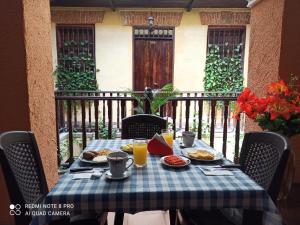 巴兰基亚hotel san nicolas colonial的阳台上的桌子上摆放着食物和饮料