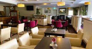 罗斯康芒汉伦斯酒店的配有桌子和粉色椅子及桌椅的餐厅