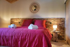 孔卡Résidence Vista Blu的一间卧室配有一张带砖墙的紫色床
