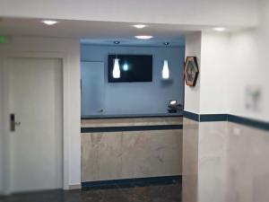 帕多瓦ANMAN HHBB tourism & business rooms的一间配有电视的房间和一个带门的走廊