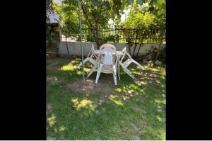 尼亚米卡尼奥纳mini studio的院子里的白色桌子和椅子