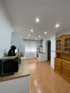 CazalegasVilla Paraiso的厨房设有白色的墙壁、木制橱柜和柜台。