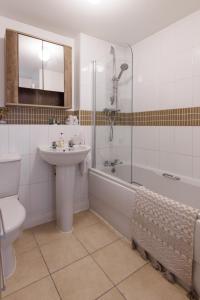 艾尔斯伯里Comfortable 4-Bedroom Home in Aylesbury Ideal for Contractors Professionals or Larger Families的一间带水槽、浴缸和卫生间的浴室