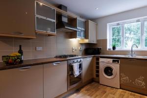 艾尔斯伯里Comfortable 4-Bedroom Home in Aylesbury Ideal for Contractors Professionals or Larger Families的厨房配有洗衣机和洗衣机。