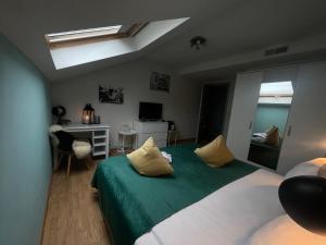 扎芬特姆Dreamland Resort的卧室配有绿色和白色的床和书桌。
