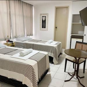 大坎皮纳Majestic Hotel的酒店客房设有两张床和一张桌子。