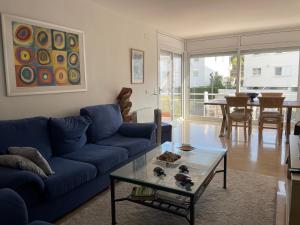 普拉加德阿罗Blue Ocean的客厅配有蓝色的沙发和玻璃桌