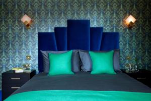 KentThe Bedford Inn的一间卧室配有蓝色的床和两个绿色枕头