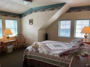 莱文沃思Beaver Valley Lodge的一间卧室设有一张床和两个窗户。