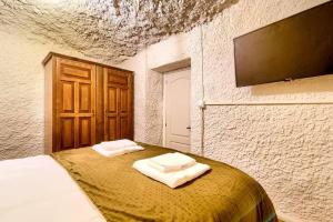 BenaguacilCueva con jacuzzi a 20 minutos de Valencia的一间卧室配有一张床,上面有两条毛巾