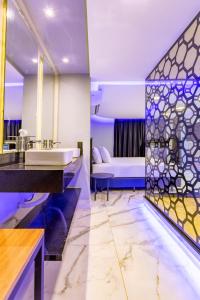 巴西利亚Drops Motel Brasília的一间带水槽的浴室和一张位于客房内的床