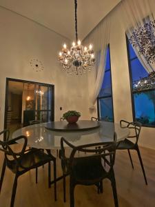 莫日-达斯克鲁济斯Casa Paradise Mogi的一间带桌椅和吊灯的用餐室