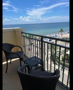 劳德代尔堡The Atlantic Hotel & Spa Condo的一个带椅子的阳台,享有海滩美景