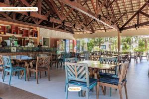 卡姆布库Térreo com churrasqueira no VG Sun por Tactu的一间带木桌椅的餐厅和一间酒吧