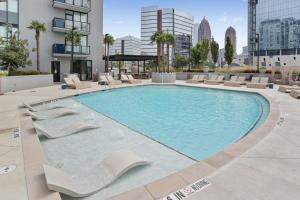 亚特兰大Midtown Luxury Apartment的一座带躺椅的大型游泳池和一座建筑
